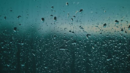 A soft whisper of rain at twilight, as droplets gently cling to the window, the day's finale in soft focus