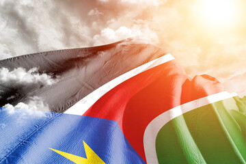 Sudan, South national flag cloth fabric waving on beautiful cloudy Background.