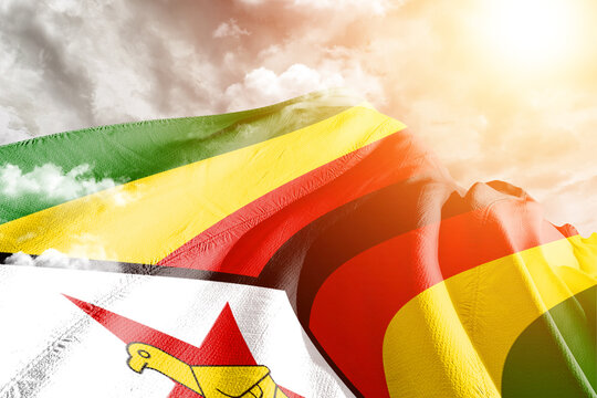 Zimbabwe national flag cloth fabric waving on beautiful cloudy Background.