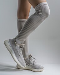 Photo of a white woman wearing grey high socks, sneakers, closeup on her legs, cute feminine body shape, athletic physique, muscular, natural light, aesthetic body pose. sports fashion advertising