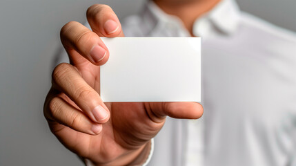 a hand holding a blank business card