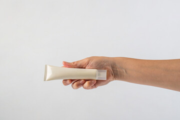 Female hand holds cosmetic product in tube, bottle, lotion or serum on white background.