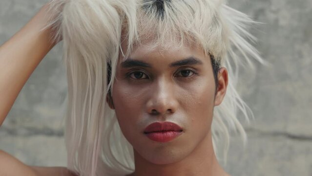Portrait of the Tearful Transgender Man Removes his Wig, Feeling Like a Victim of Social Condemnation. LGBTQ Queer Depressed and Lonely Guy Looking at the Camera. LGBT Concept