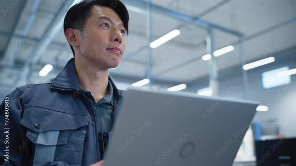 Poster handsome factory manager working on laptop at an industrial manufacture with autonomous technology. 