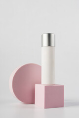 Plastic white tube for cream or lotion. Skin care or sunscreen cosmetic with stylish props on white background.