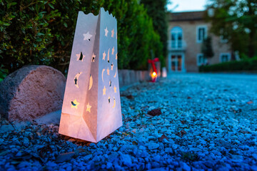 paper lanterns glowing at dusk along a pebbled path