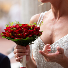 bride in a sequin dress holding a bouquet of red chili and roses