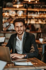 Young Businessman Working on Laptop at Table