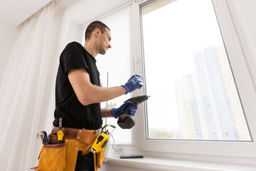Young worker checking window after repair