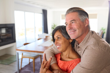 Close Up Of Loving Mature Couple Hugging In Lounge At Home