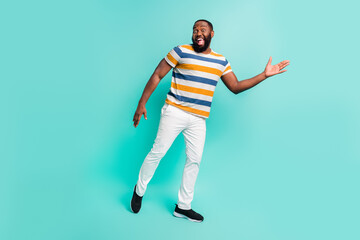 Fototapeta na wymiar Full length photo of carefree cool man wear striped t-shirt having fun isolated teal color background