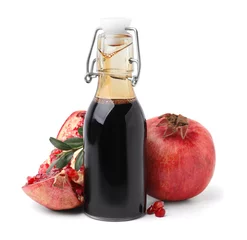 Poster Tasty pomegranate sauce in bottle, fruits and branch isolated on white © New Africa