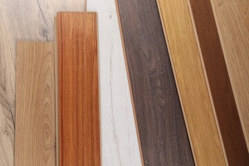 Different samples of wooden flooring as background, top view