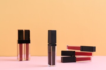 Many different lip glosses on color background
