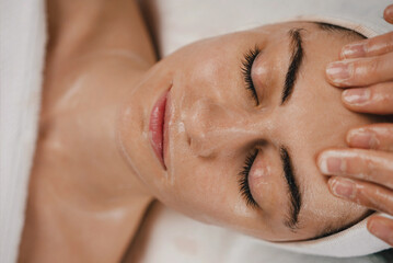 Shot of a beautiful young woman enjoying face massage at the beauty salon. Facial massage beauty...