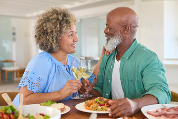 Fototapeta na wymiar Loving Mature Couple At Home Enjoying Lunch With Wine Together
