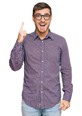 Handsome caucasian man wearing casual clothes and glasses pointing finger up with successful idea....