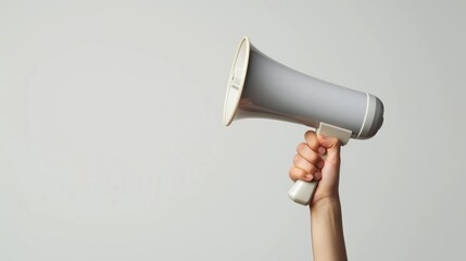 A hand holding a white megaphone on a white background. Copy space. - obrazy, fototapety, plakaty