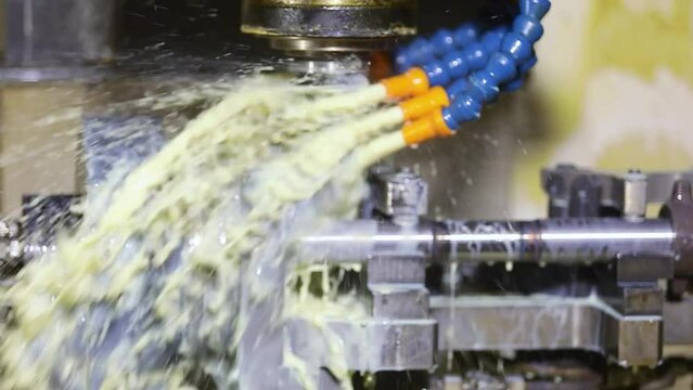 CNC turning machine high precision throwing coolant liquid on metal component tool shaping forming process by vertical machining center control automation milling workpiece using rotating cutting