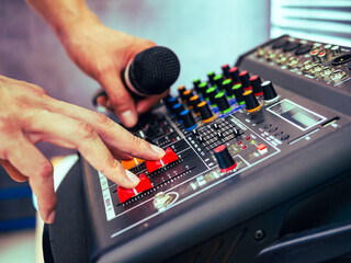 Close-up of sound engineer hands adjusting control sound mixer in recording, broadcasting...