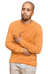 Hispanic adult man wearing casual winter sweater with hand on stomach because nausea, painful disease feeling unwell. ache concept.