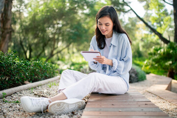 Content woman writing in notebook at public park