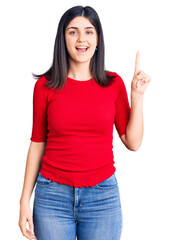 Young beautiful girl wearing casual t shirt pointing finger up with successful idea. exited and happy. number one.