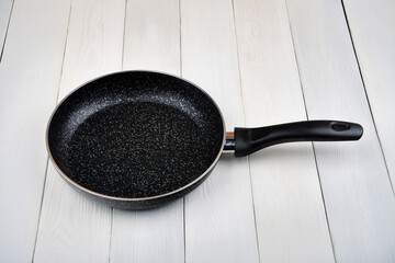Metal Frying Pan:On a white, wooden insulated background. A place for the text.Ceramic coating with...