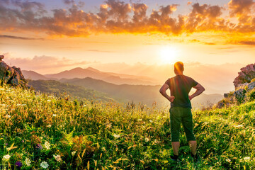 happy man watching amazing highland evening sunset, person delight with nature landscape
