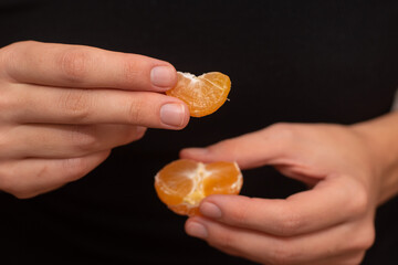 Peeling a Fresh Orange Mandarin. Female Hands skillfully peeling a juicy ripe mandarin.