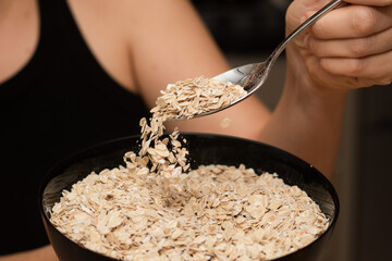 Serving Oats with a Spoon. Scooping oats from a bowl with a metal spoon.
