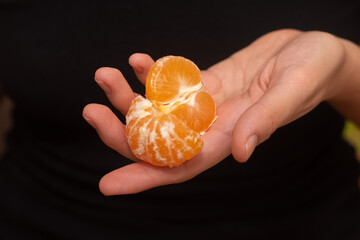Peeling a Fresh Orange Mandarin. Female Hands skillfully peeling a juicy ripe mandarin.