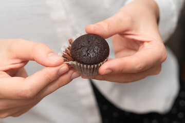 Hands Holding Chocolate Muffins. Presenting freshly baked chocolate muffins.