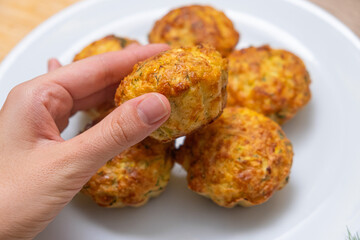 Savory Muffin in a female Hand. Hand selecting a golden-baked savory muffin.