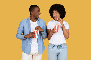 Couple eating popcorn and looking at each other