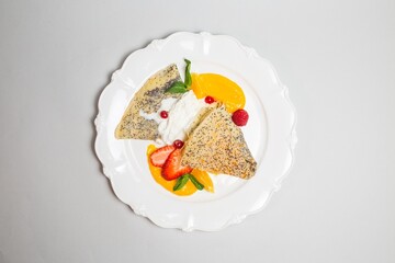 Poppy seed pancakes with strawberries, blueberries and cream cheese glaze top view