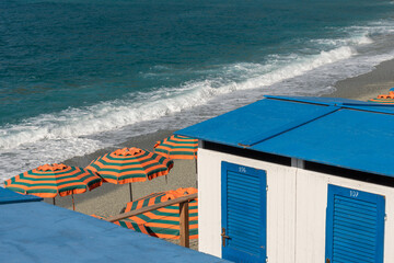 High angle view of colorful beach cabins and umbrellas against sea