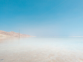 Landscape view on Dead Sea salt crystals formations, clear cyan green water at Ein Bokek beach,...