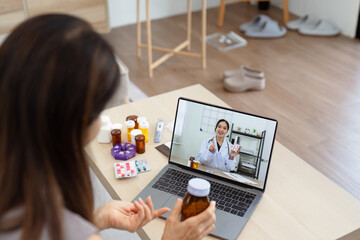 Senior Asian woman video calling with doctor on tablet, consultation health issues and medication online. Doctor concept of telemedicine - obrazy, fototapety, plakaty
