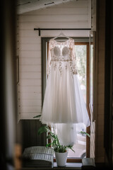 Valmiera, Latvia - Augist 13, 2023 - An elegant white wedding dress with lace details is hanging...