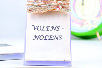Willy - nilly latin expression volens-nolens (willing or unwilling) written on the desktop calendar