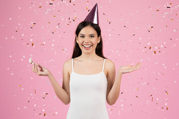 Woman with party hat and confetti falling around