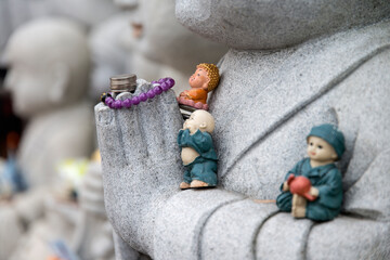 coins on the monk sculpture with the small monk dolls