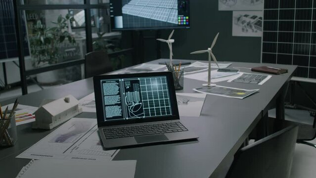 No people footage of solar panel layout on laptop screen on table near myriads of documents in modern loft renewable energy office