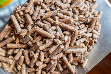 A pile of organic wooden pellets made from compacted sawdust of woodworking operations. Alternative energy, ecological heating, biofuel concept. Close up