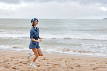 The Active Beach Runner: A Young Female Jogger Embracing Health and Freedom in a Serene Summer Sunset on the Sandy Shore