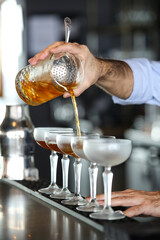 Bartender pouring cocktail into glass, mix cocktail, mix drinks, classic cocktail.