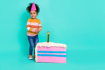 Photo of funny small lady birthday entertainment concept pinata cake wear striped pullover isolated teal color background