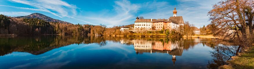 High resolution stitched alpine winter panorama with a monastery and reflections at the famous Lake...