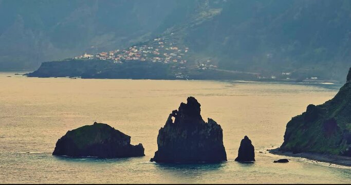 Aerial view of the Ilheus da rib arch, on the coastline of Ribeira da Janela in Madeira, Portugal. The village of Seixal can be seen in the background